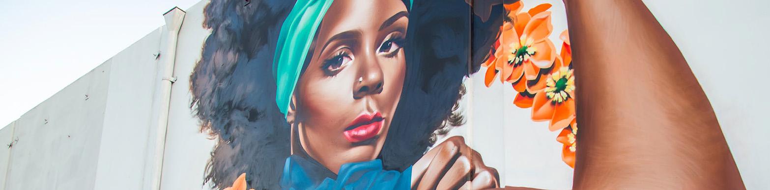 Mural of a black woman dressed as rosie the riveter